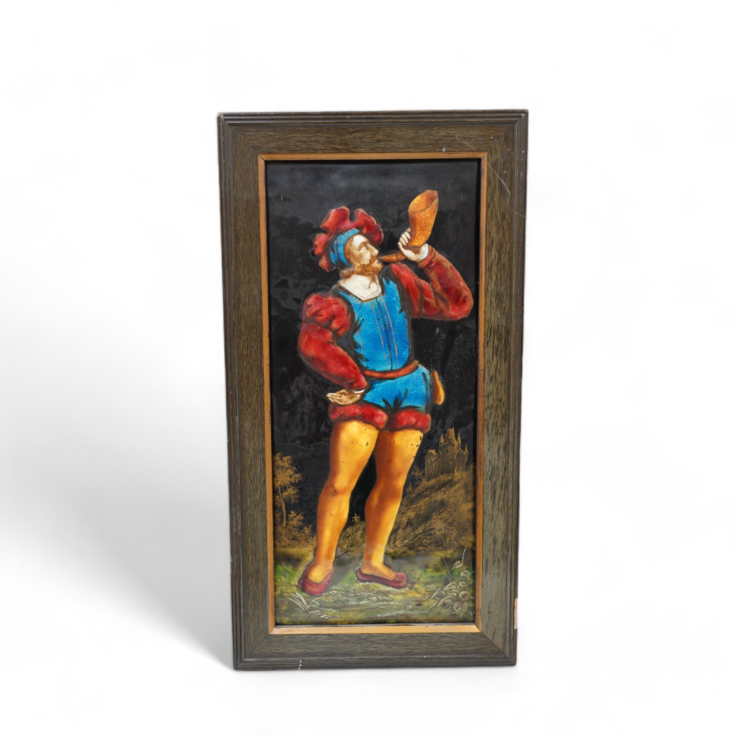 A framed Limoges enamel panel of a medieval man blowing a horn, overall 47 x 25cm. Condition - good